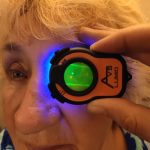 Woman undergoing advanced eye examination with the Lumio device and clip-in fluorescein wratten filter by Aston Vision Sciences