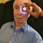 Older patient undergoing eye examination in their home