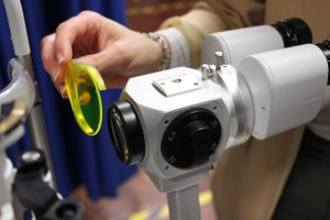 Fluorescein Wratten filter being attached to a slit lamp for anterior eye examination